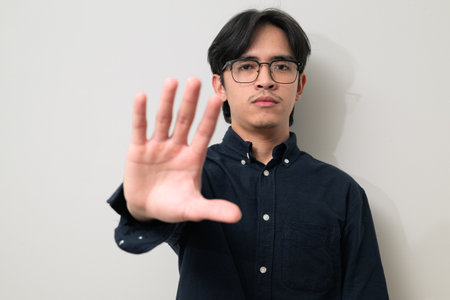 Portrait of handsome Young Asian Thai man in early 20s against white backgroundの写真素材