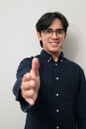 Portrait of handsome Young Asian Thai man in early 20s against white backgroundの写真素材