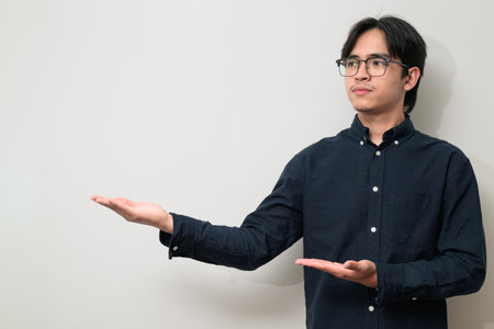 Portrait of handsome Young Asian Thai man in early 20s against white backgroundの写真素材