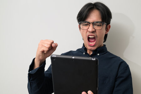 Portrait of Young Asian Thai man in early 20s against white backgroundの写真素材