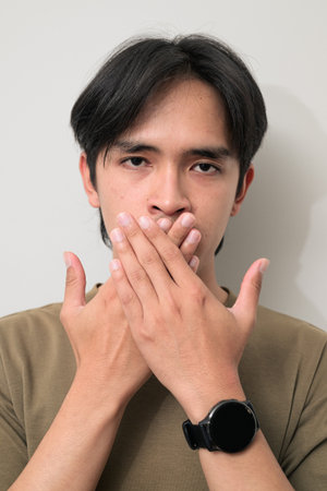 Portrait of handsome Young Asian Thai man in early 20s against white backgroundの写真素材