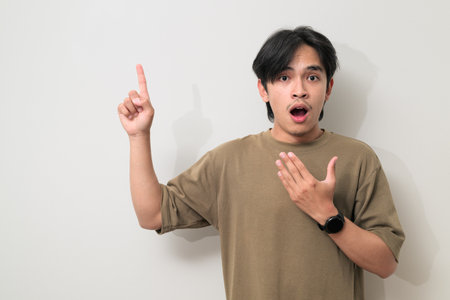 Portrait of handsome Young Asian Thai man in early 20s against white backgroundの写真素材