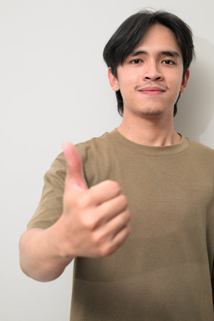 Portrait of handsome Young Asian Thai man in early 20s against white backgroundの写真素材