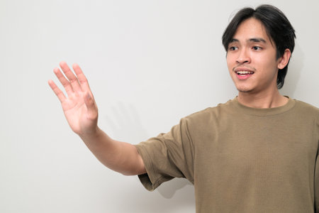 Portrait of handsome Young Asian Thai man in early 20s against white backgroundの写真素材