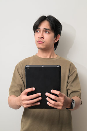 Portrait of handsome Young Asian Thai man in early 20s against white background