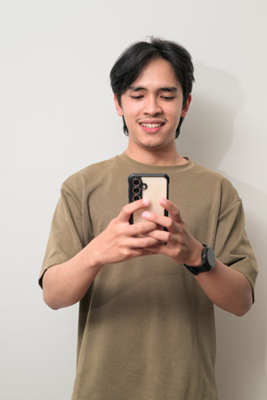 Portrait of handsome Young Asian Thai man in early 20s against white backgroundの写真素材