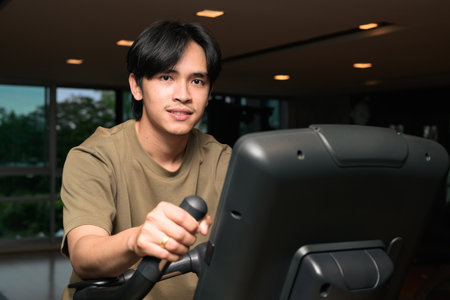 Portrait of handsome Young Asian Thai man in early 20s at gym during nightの写真素材