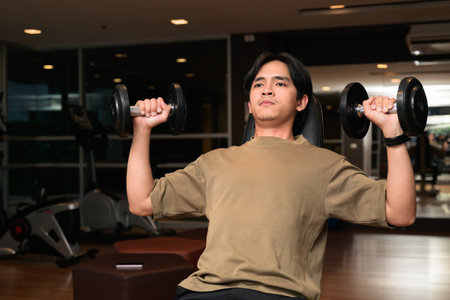 Portrait of handsome Young Asian Thai man in early 20s at gym during nightの写真素材
