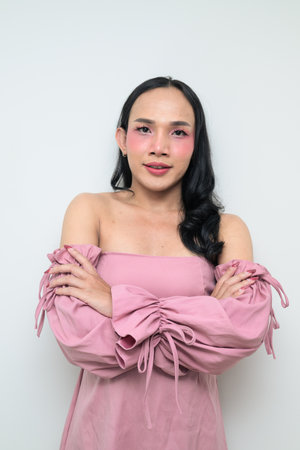Studio portrait of a young Thai transgender individual with makeup and long hair. Concept of gender expression, LGBTQ pride, and inclusivity showing authentic beauty and diversity.の写真素材