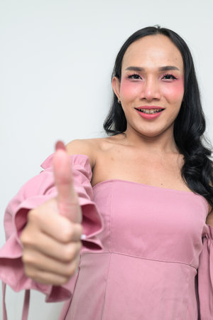 Studio portrait of a young Thai transgender individual with makeup and long hair. Concept of gender expression, LGBTQ pride, and inclusivity showing authentic beauty and diversity.の写真素材