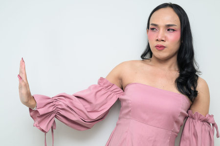 Studio portrait of a young Thai transgender individual with makeup and long hair. Concept of gender...