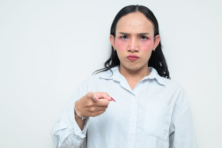 Studio portrait of a young Thai transgender individual with makeup and long hair. Concept of gender...
