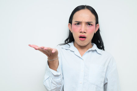 Studio portrait of a young Thai transgender individual with makeup and long hair. Concept of gender expression, LGBTQ pride, and inclusivity showing authentic beauty and diversity.の写真素材