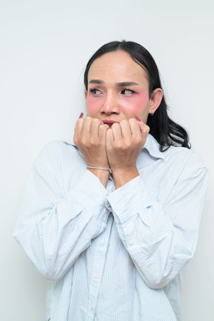 Studio portrait of a young Thai transgender individual with makeup and long hair. Concept of gender...