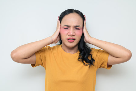 Studio portrait of a young Thai transgender individual with makeup and long hair. Concept of gender expression, LGBTQ pride, and inclusivity showing authentic beauty and diversity.の写真素材