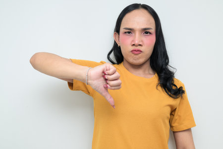 Studio portrait of a young Thai transgender individual with makeup and long hair. Concept of gender expression, LGBTQ pride, and inclusivity showing authentic beauty and diversity.の写真素材