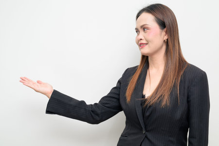 Studio portrait of an Asian business woman wearing a black blazer against a white background....