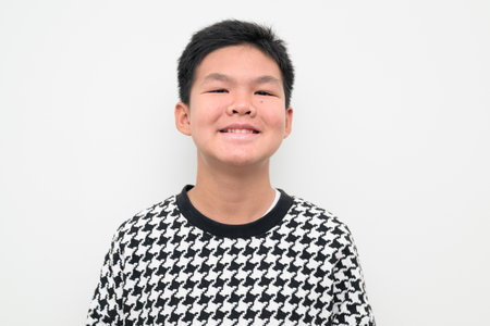 Studio portrait of an Asian teenage boy standing against a plain white background. Simple look suitable for youth, education, family, and lifestyle themes.の写真素材