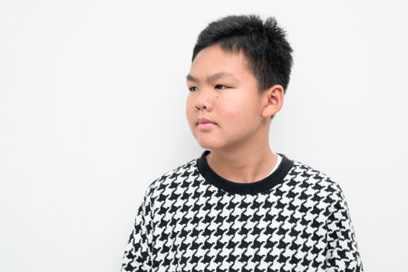Studio portrait of an Asian teenage boy standing against a plain white background. Simple look suitable for youth, education, family, and lifestyle themes.の写真素材