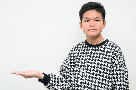 Studio portrait of an Asian teenage boy standing against a plain white background. Simple look suitable for youth, education, family, and lifestyle themes.の写真素材