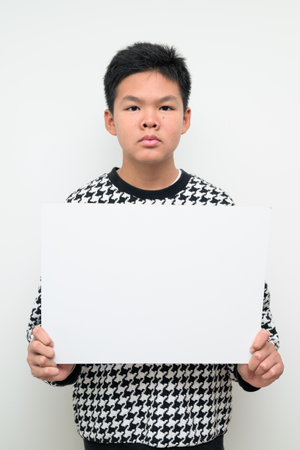 Studio portrait of an Asian teenage boy standing against a plain white background. Simple look suitable for youth, education, family, and lifestyle themes.の写真素材