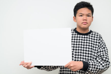 Studio portrait of an Asian teenage boy standing against a plain white background. Simple look suitable for youth, education, family, and lifestyle themes.の写真素材