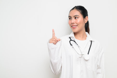 Portrait of a female healthcare professional in a white medical uniform with a stethoscope, standing against a clean studio background. Suitable for medical, hospital, and clinical themes.の写真素材