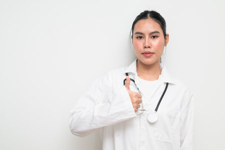 Portrait of a female healthcare professional in a white medical uniform with a stethoscope, standing against a clean studio background. Suitable for medical, hospital, and clinical themes.の写真素材