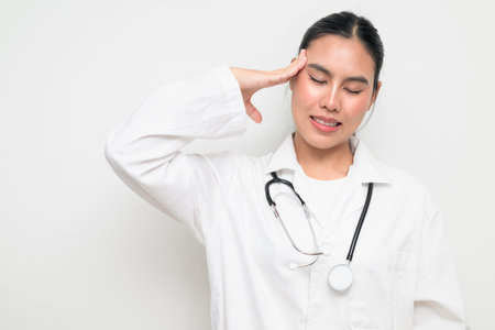 Portrait of a female healthcare professional in a white medical uniform with a stethoscope, standing against a clean studio background.の写真素材