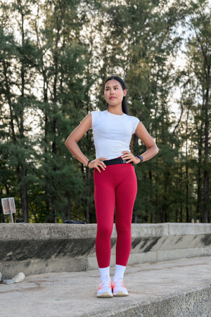 Fit Asian Woman in Sportswear Standing Outdoors in Park Environmentの写真素材