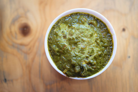 Top View of Delicious Indian Palak Paneer Curry on Wooden Table