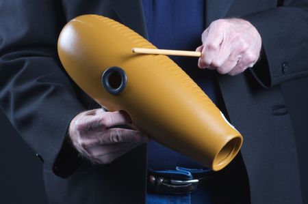 A guiro gourd percussion instrument being played against a black background in the horizontal format with copy space.の写真素材
