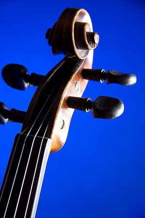 A violin scroll isolated on a blue background in the vertical format.の写真素材