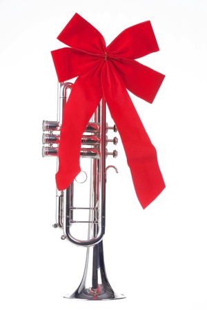 A Christmas silver trumpet with a red bow isolated against a white background.の写真素材