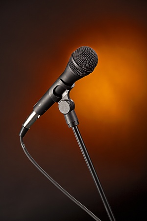 A modern microphone isolated against a spotlight gold background in the vertical format.の写真素材