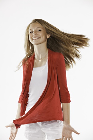 A pretty long brown hair teenage female girl leaning against a wall isolated on a white backgroundの写真素材