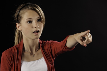 A pretty teenage female girl isolated against a black background.の写真素材