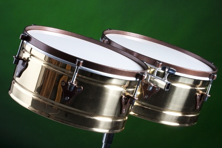 A set of brass and copper timbales isolated on a green background in the horizontal format.の写真素材