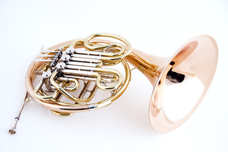 A French horn isolated close-up against a high key white background in the horizontal view with copy...