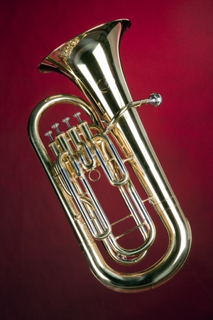 A tuba bass euphonium music instrument isolated against a spotlight red background.の写真素材