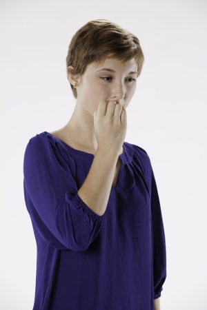 Pretty thoughtful teenage female girl with red brown hair and purple shirt isolated considering the options on a white background の写真素材