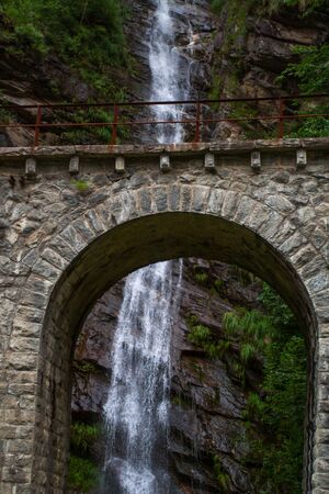 A bridge with a waterfall in the background - Switzerlandの写真素材