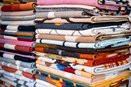Colorful rugs and textile fabrics for sale at Dilli Haat New Delhi India, a market filled with colorful handicrafts and handmade itemsの写真素材