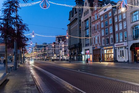 Amsterdam, Netherlands - November 9, 2019: Pre sunrise early morning in Amsterdam, with shops lit up for Christmas, and empty streetsの写真素材