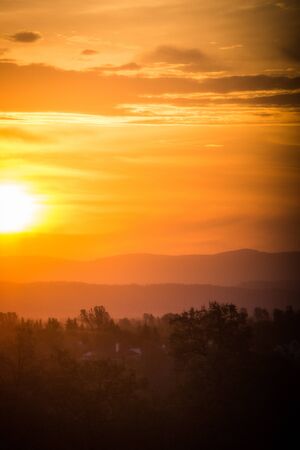 Hazy colorful mountain sunrise in Redding California, with orange, red and yellow colorsの写真素材