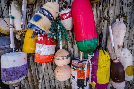 Old weathered bouys attached to a wooden shed on Cape Codの写真素材