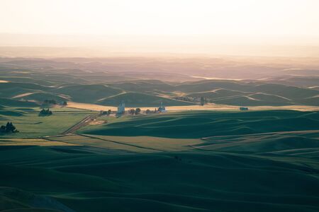 Beautiful hazy sunset from Steptoe Butte in the Palouse of Washington State, with shadows on the rolling hills of farmlandの写真素材