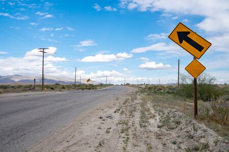 Diagonal arrow signs warn drivers of upcoming curves and hills. Taken in North Shore, California in the Salton Sea area of Imperial Countyの写真素材