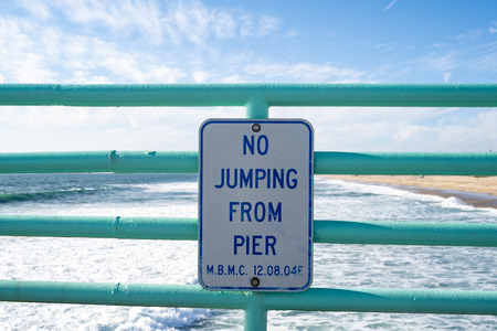 Sign warns visitors no jumping from the pier. Taken in Manhattan Beach, Californiaのeditorial素材