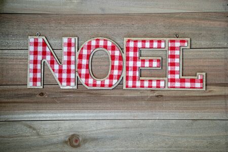 Rustic Christmas background with the word NOEL in red and white plaid. Wood background, copyspace roomの写真素材